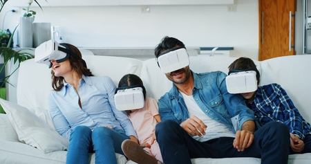 Portrait of happy family using vr glasses in living room in slow motion. Concept of innovation technology, family entertainment, gameの写真素材
