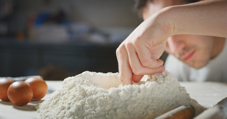A baker prepares flour on his traditional wooden table. Concept of: tradition, flour, bakery.の写真素材