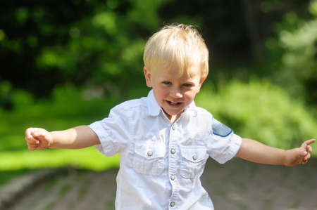 portrait of playing boy on grass in gardenの写真素材