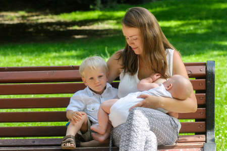 mother with newborn child during breast feeding in gardenの写真素材