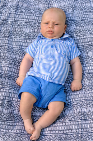 little boy lies on blue cover background