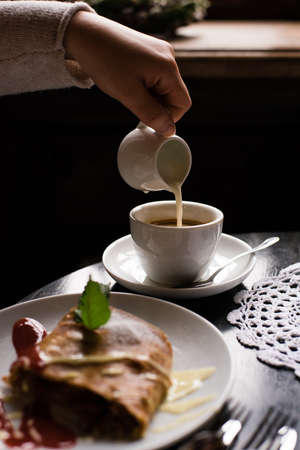 coffee cup and cake on black wooden table in cafeの写真素材