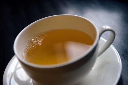 cup of green tea on dark wooden table