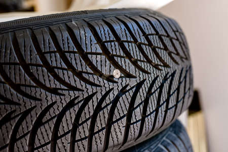 metallic nail in damaged tyre before repairの写真素材