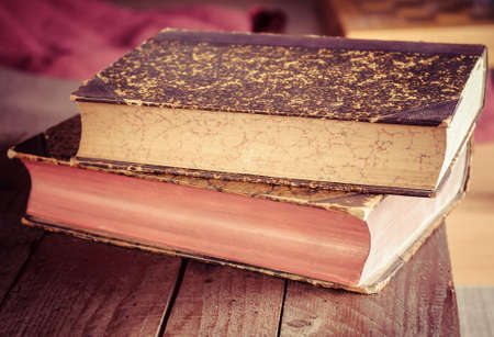 pile of old books on wooden brown table in bookstore (Shallow depth of field)
