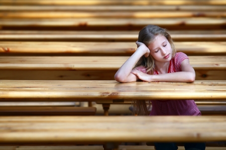 The girl, the teenager sits at a table の写真素材