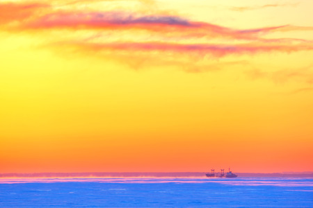 The tanker in ice-rinks at sunset in the winterの写真素材