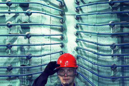 The worker in a helmet at factory.Industrial interior.
