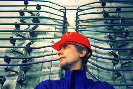 The worker in a helmet at factory.Industrial interior.