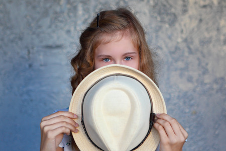 Young girl with hat. Hides her face.Depression.Photo tinted and styled with vintage photo.の写真素材