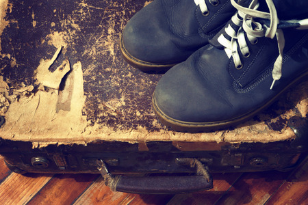 Boots and old suitcase.Photo toned in retro style.の写真素材