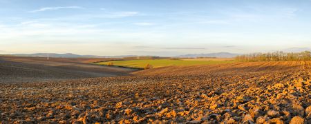 Panorama of landscape with blue sky above the plowed fieldsの写真素材