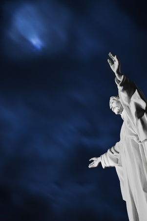 Night scene with a statue of Jesus Christ in the forefrontの写真素材