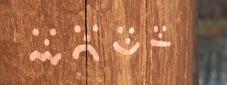 Set of four smileys drawing on woodの写真素材