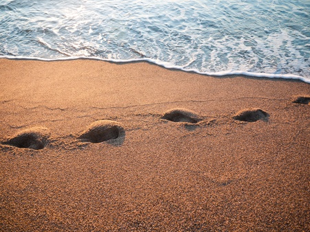 sea water flooded the human footprint on the beachの写真素材