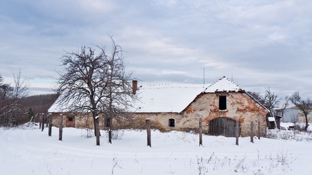 Abandoned farm house in the middle of a snowy landscapeの写真素材