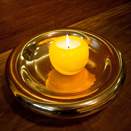Burning candle in a luxurious golden candlestickの写真素材