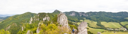 Hiker standing on rocky ridge and looking at the natural landscape typical for the northern part of...