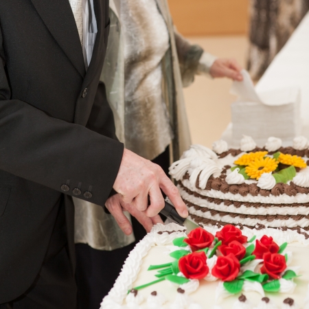 Hands of man cut of a slice of a jubilee cakeの写真素材