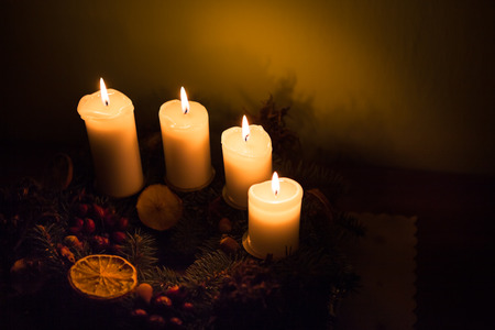 Advent candles glowing on the seasonal decorationsの写真素材
