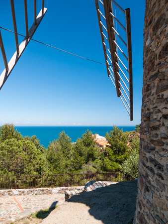 Windmill on the Mediterranean sea coast with blue skyの写真素材