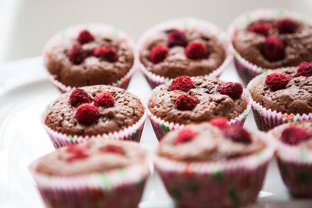 Homemade muffins with raspberries on white plateの写真素材