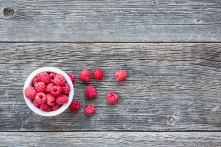 Top view of ripe raspberries on wooden background with copy space for text