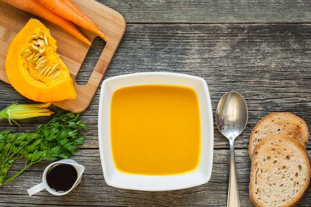 Hokkaido pumpkin soup in a white ceramic bowl with toasted breadの写真素材