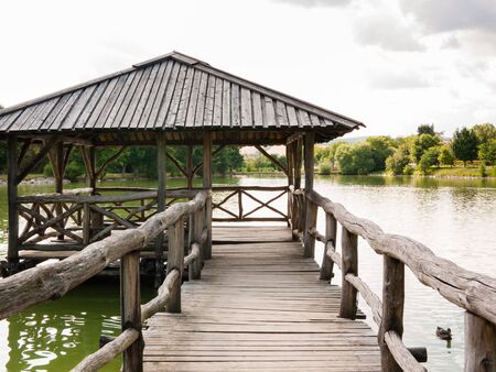 Old Wooden fishing house on pier and beautiful lake background. Picturesque lake sceneryの写真素材