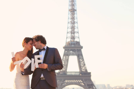 Bride and groom holding LOVE letters in their hand in Paris, Franceの写真素材