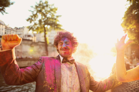 bride and groom having fun with holi powderの写真素材