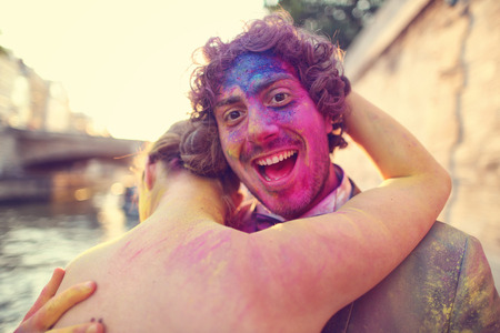 Portrait of a bride and groom having fun with holi powderの写真素材