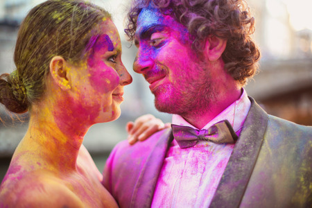 Bride and groom in the city with holi powderの写真素材