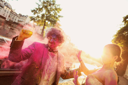 Portrait of a bride and groom having fun with holi powderの写真素材