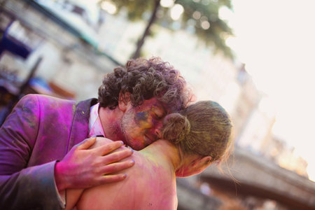 Bride and groom in the city with holi powderの写真素材