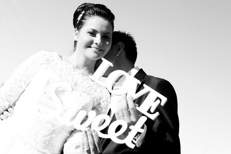 black and white photo of a groom kissing bride on her neckの写真素材