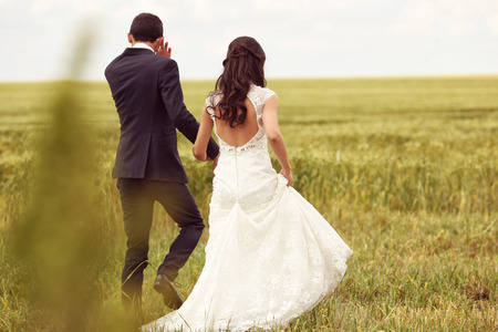 Bride and groom posing in the fieldsの写真素材