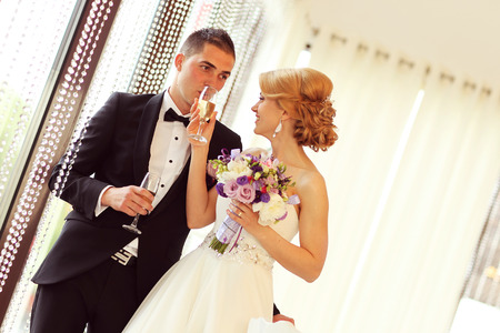 groom and bride holding champagne glassesの写真素材