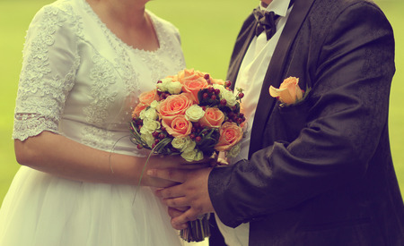 Bride holding her wedding bouquet made of rosesの写真素材