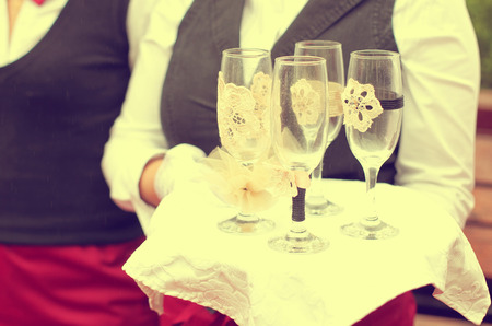 waiter with 4 champagne glasses on a trayの写真素材