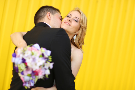 Bride and groom on a yellow backgroundの写真素材