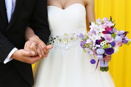 Bride and groom on a yellow backgroundの写真素材