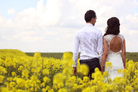 Bride and groom posing in the fieldsの写真素材