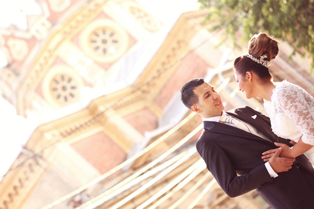 Bride and groom holding hands near churchの写真素材