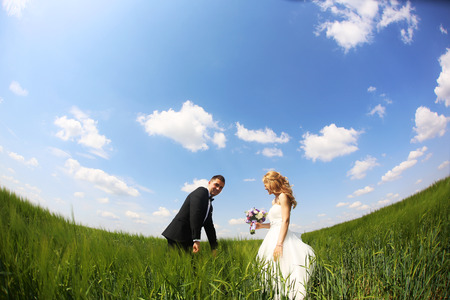 Bride and groom having fun on the fieldsの写真素材