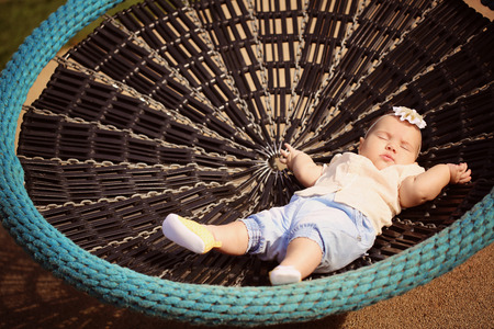 Beautiful baby girl sleeping in a bouncerの写真素材