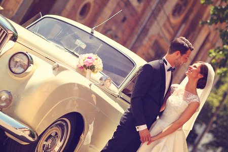Bride and groom with a retro carの写真素材