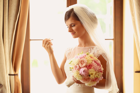 Emotional bride in her wedding day holding peonies bouquetの写真素材