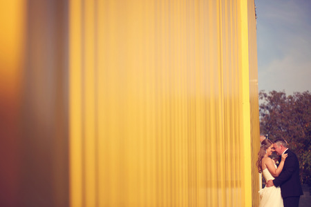 Bride and groom near yellow wallの写真素材