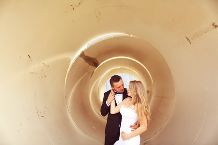 Bride and groom posing in a pipeの写真素材